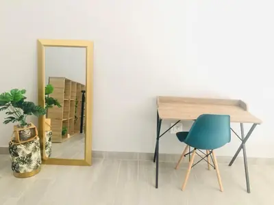 a mirror next to a table and a blue chair at Loft apartment by the lake in Cape Town
