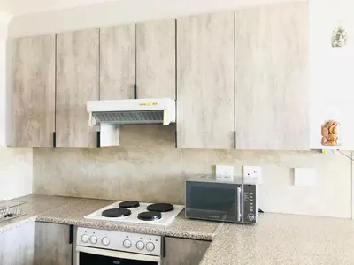 a kitchen with a microwave and a stove top oven at Loft apartment by the lake in Cape Town