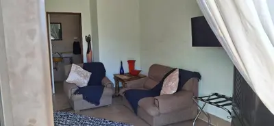 a living room with two couches and a tv at Arendsnest Self Catering in Gordonʼs Bay