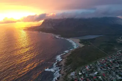 an aerial view of the ocean and a mountain at La Mer Seafront Selfcatering Accommodation Kleinmond in Kleinmond