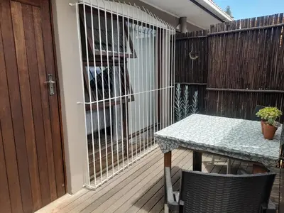 a patio with a table and a fence at Cornerstone Guesthouse Drostdy in Panorama