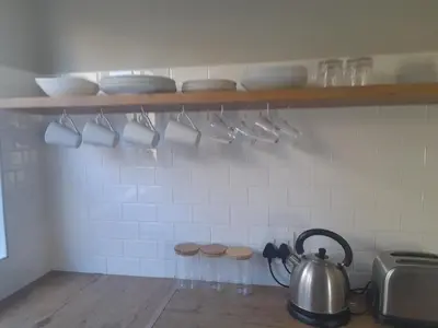 a kitchen with a tea kettle and cups on a shelf at Cornerstone Guesthouse Drostdy in Panorama