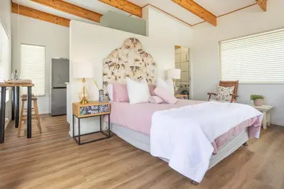 a bedroom with a large bed and a table at Studio 98 - 300m from cliff path in Hermanus