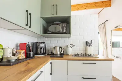 a kitchen with white cabinets and a microwave at Studio 98 - 300m from cliff path in Hermanus