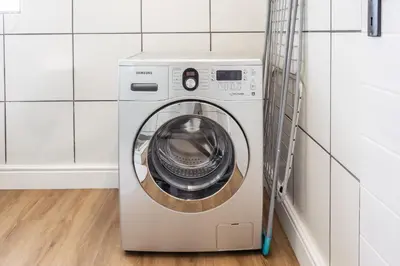 a washer and dryer in a white laundry room at Studio 98 - 300m from cliff path in Hermanus