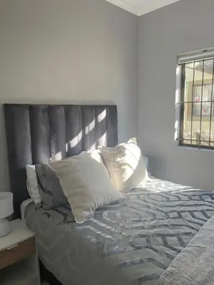 a bed with white pillows on it in a bedroom at Beautiful 2 bedroom apartment in strand in Somerset West