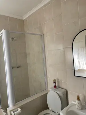 a bathroom with a shower and a toilet and a sink at Beautiful 2 bedroom apartment in strand in Somerset West