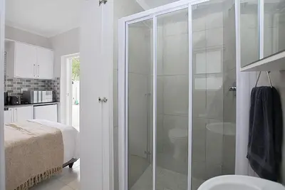 a bathroom with a shower with a glass door at Leetch Views - Budget Room in Cape Town
