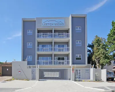 a large apartment building with a white fence in front of it at Leetch Views - Budget Room in Cape Town