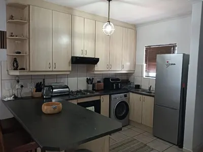 a kitchen with a refrigerator and a dishwasher at ESME's REST in Cape Town