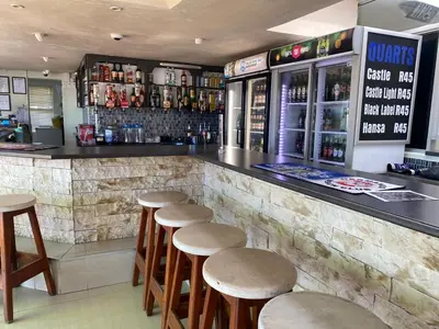a bar with a row of stools in a restaurant at Oceanfront Escape with Spacious Balcony Hermanus in Hermanus