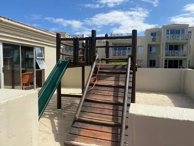 a playground with a slide on top of a building at Oceanfront Escape with Spacious Balcony Hermanus in Hermanus
