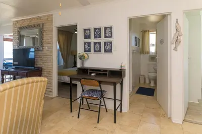 a living room with a desk and a chair at Oceanfront Escape with Spacious Balcony Hermanus in Hermanus