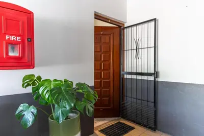 a red door and a potted plant in front of a door at Tweede Boom in Cape Town