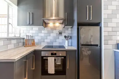 a kitchen with a stove and a refrigerator at Tweede Boom in Cape Town