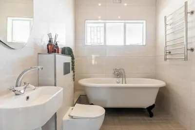 a bathroom with a tub and a toilet and a sink at Tweede Boom in Cape Town