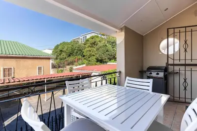 a white table and chairs on a balcony at Tweede Boom in Cape Town