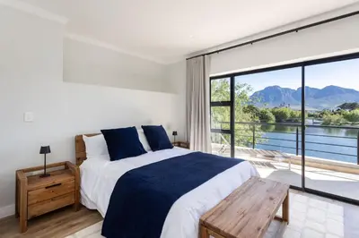 a bedroom with a bed and a large window at Luxury Lodge 5B, Pearl Valley Golf Estate in Simondium