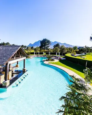 a large swimming pool in a resort at Luxury Lodge 5B, Pearl Valley Golf Estate in Simondium