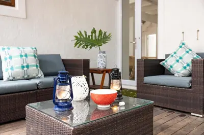 a living room with a couch and a table at Onrus Island Milkwood Sanctuary in Hermanus