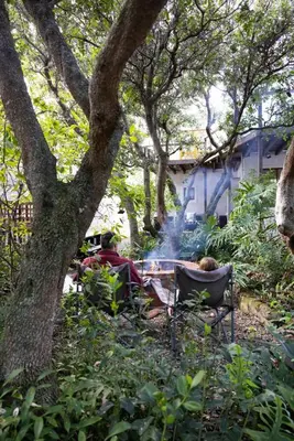 a group of people sitting around a camp fire at Onrus Island Milkwood Sanctuary in Hermanus