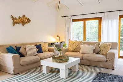 a living room with two couches and a coffee table at Onrus Island Milkwood Sanctuary in Hermanus