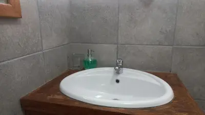 a white sink in a bathroom with a glass at 'The Cape Robin' studio apartment in Hoheizen
