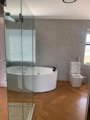 a bathroom with a bath tub and a toilet at Classy 3 storey house in Gordonʼs Bay