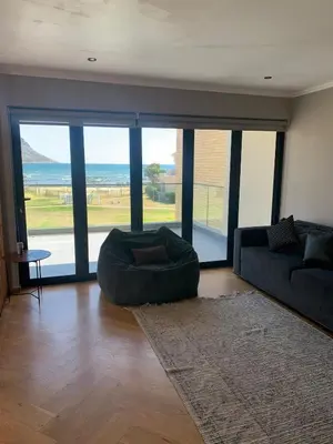 a living room with a couch and a large window at Classy 3 storey house in Gordonʼs Bay