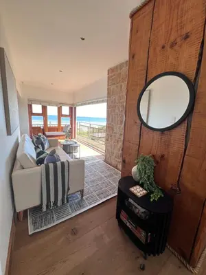 a living room with a couch and a mirror at Unique views Betties Bay in Bettyʼs Bay