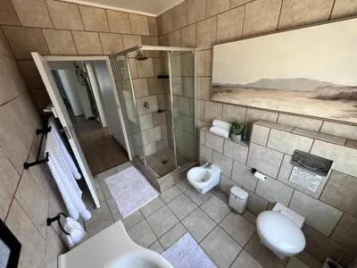 a bathroom with two sinks and a shower at Unique views Betties Bay in Bettyʼs Bay