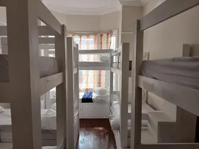 a room with three bunk beds and a window at Star legend backpackers - Parow in Parow