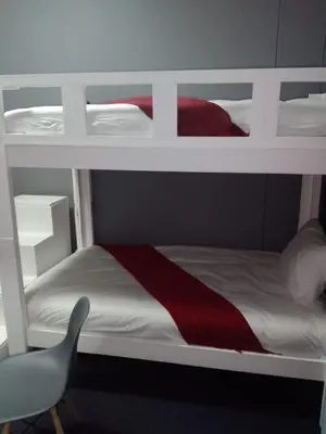two bunk beds in a room with a chair at Star legend backpackers - Parow in Parow