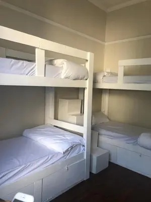 two bunk beds are in a room withermottermott at Star legend backpackers - Parow in Parow
