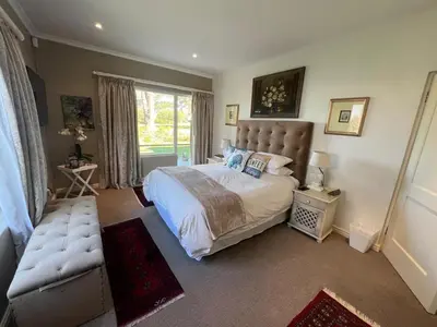 a bedroom with a large bed and a window at 16 on Fernkloof in Hermanus