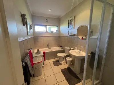 a bathroom with a sink and a tub and a toilet at 16 on Fernkloof in Hermanus