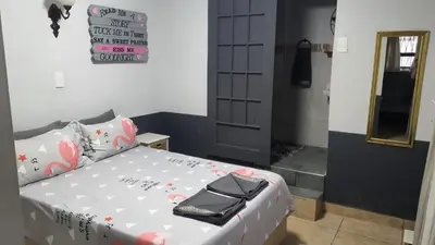 a bedroom with a bed with a black purse on it at Shalom Batchelor in Strand