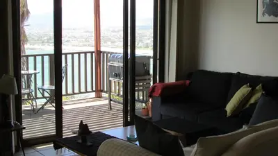 a living room with a couch and a balcony at View Panoramica Self-Catering Apartment in Gordonʼs Bay