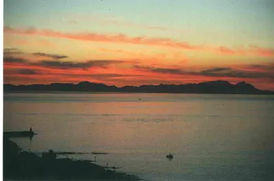 a sunset over a large body of water at View Panoramica Self-Catering Apartment in Gordonʼs Bay