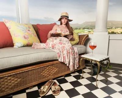 a woman sitting on a couch with a glass of wine at Rooiheuwel in Botrivier