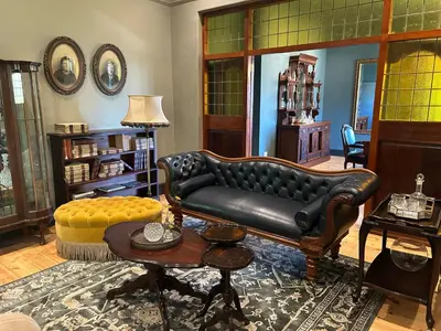 a living room with a leather couch and a table at Rooiheuwel in Botrivier