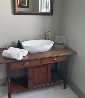 a bathroom sink with a bowl on a wooden table at Rooiheuwel in Botrivier