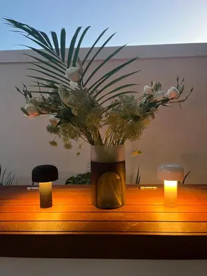 a vase with flowers on a table with two candles at The Alma House 1900 in Cape Town