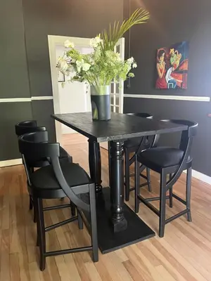 a black table with black chairs and a vase with flowers at The Alma House 1900 in Cape Town
