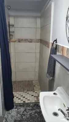 a bathroom with a white sink and a shower at Shalom Batchelor in Strand