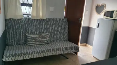 a green couch with two pillows on it in a room at Shalom Batchelor in Strand
