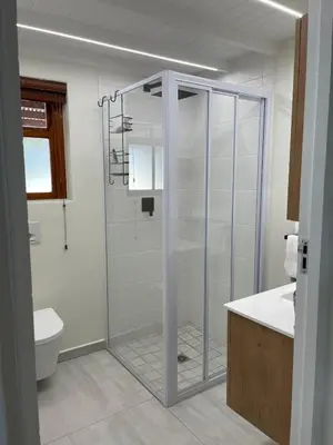 a bathroom with a shower with a glass door at The Cottage - a tranquil hideaway in Somerset West