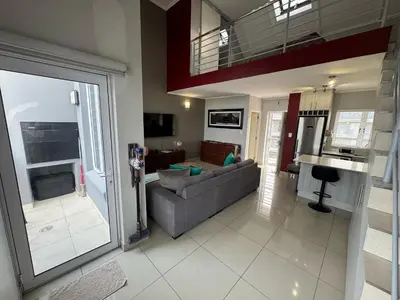 a living room with a couch and a table at Stylish Loft apartment in the heart of Durbanville in Durbanville