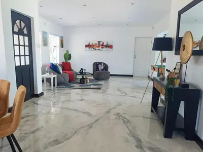 a living room with a large marble floor at Frangipani House in Goodwood