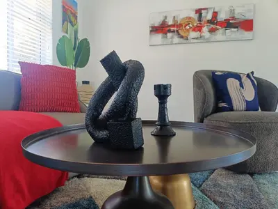 a living room with a table with a chess piece on it at Frangipani House in Goodwood